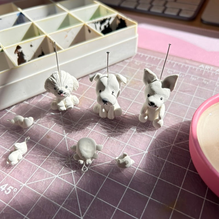 Small white dog figurines on a grid surface with a keyboard in the background
