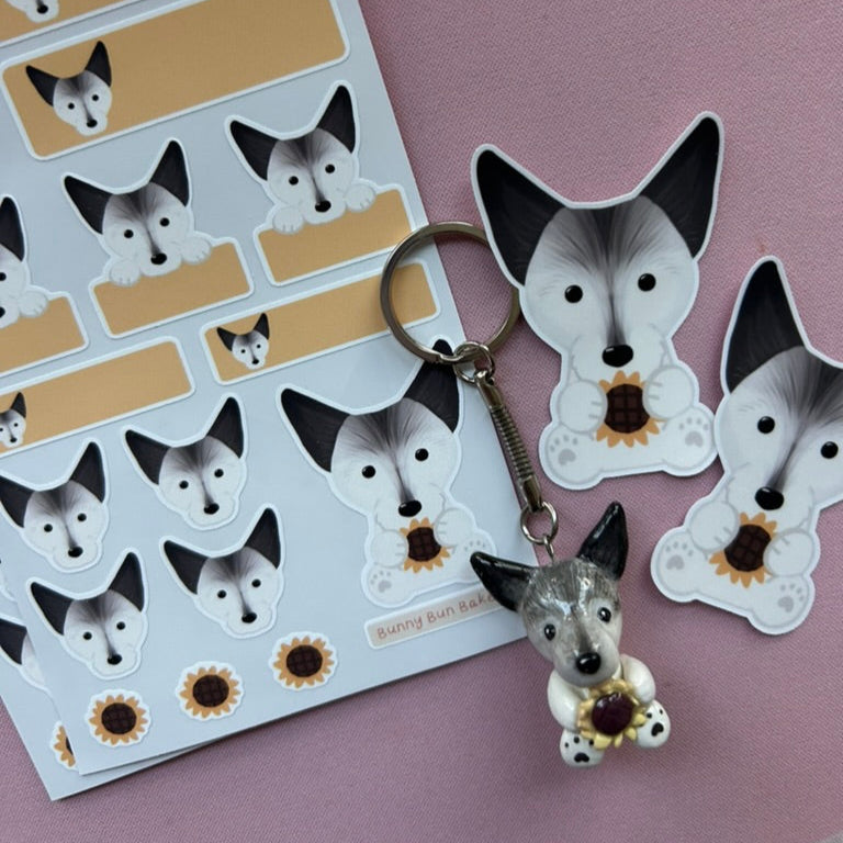 Dog-themed keychain and stickers on a purple background